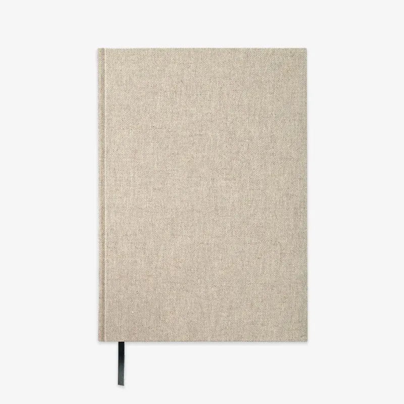 A hardcover notebook with a textured beige linen cover and a black ribbon bookmark, shown against a plain white background.