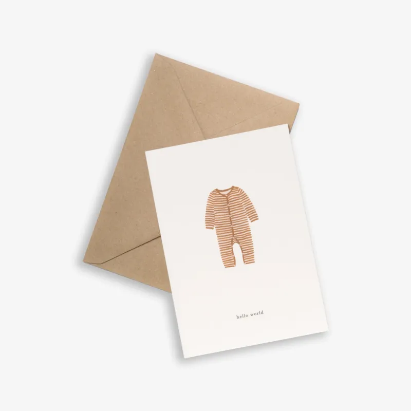 A greeting card with a baby onesie printed in ochre color with the text 'hello world', accompanied by a brown kraft envelope.